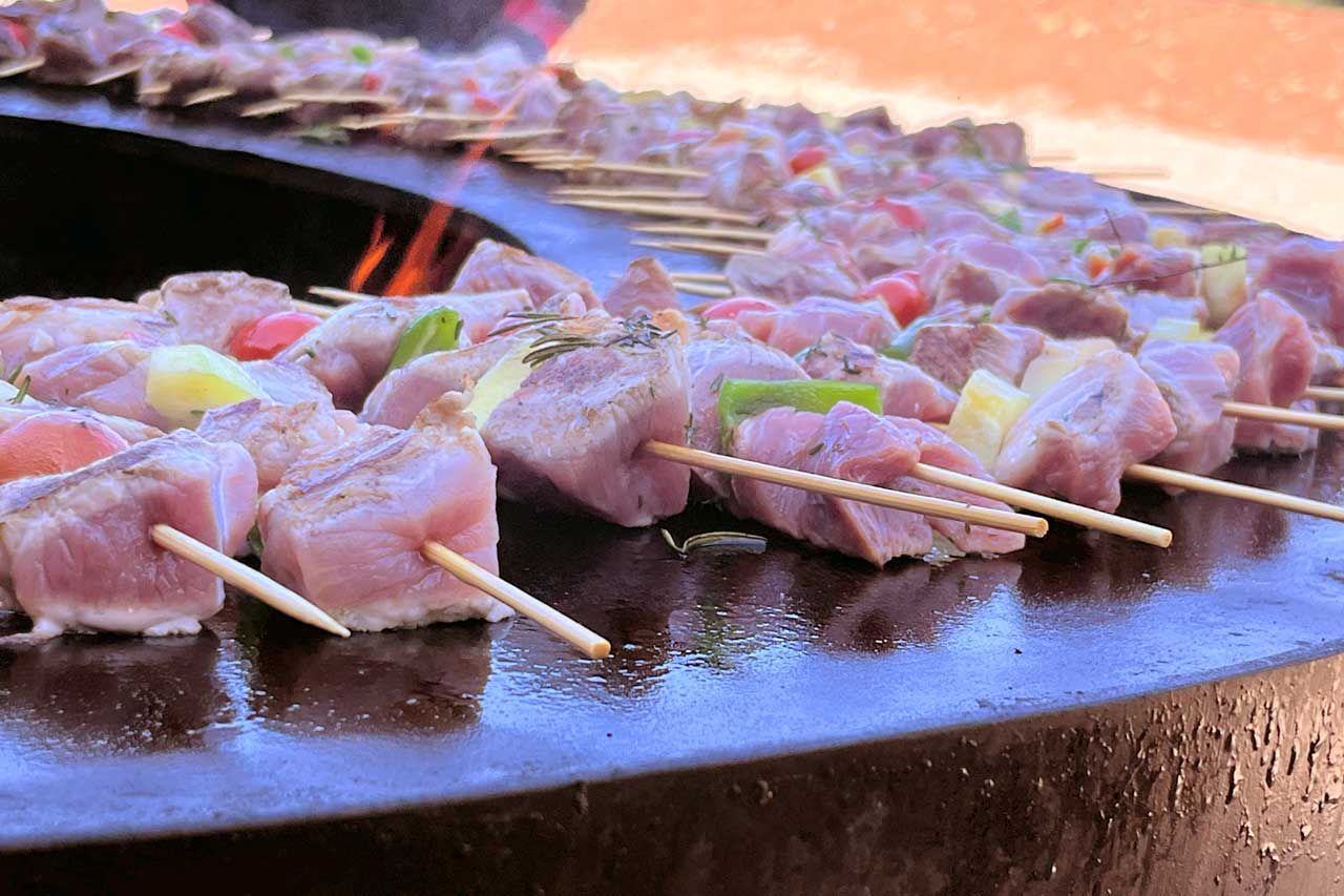 Un brasero rempli de brochettes de viandes