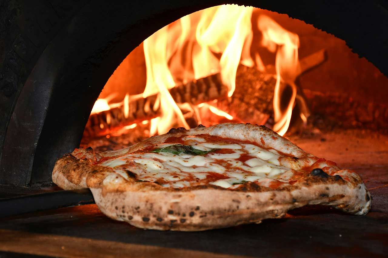 Une pizza en train de cuire dans un four à pizza